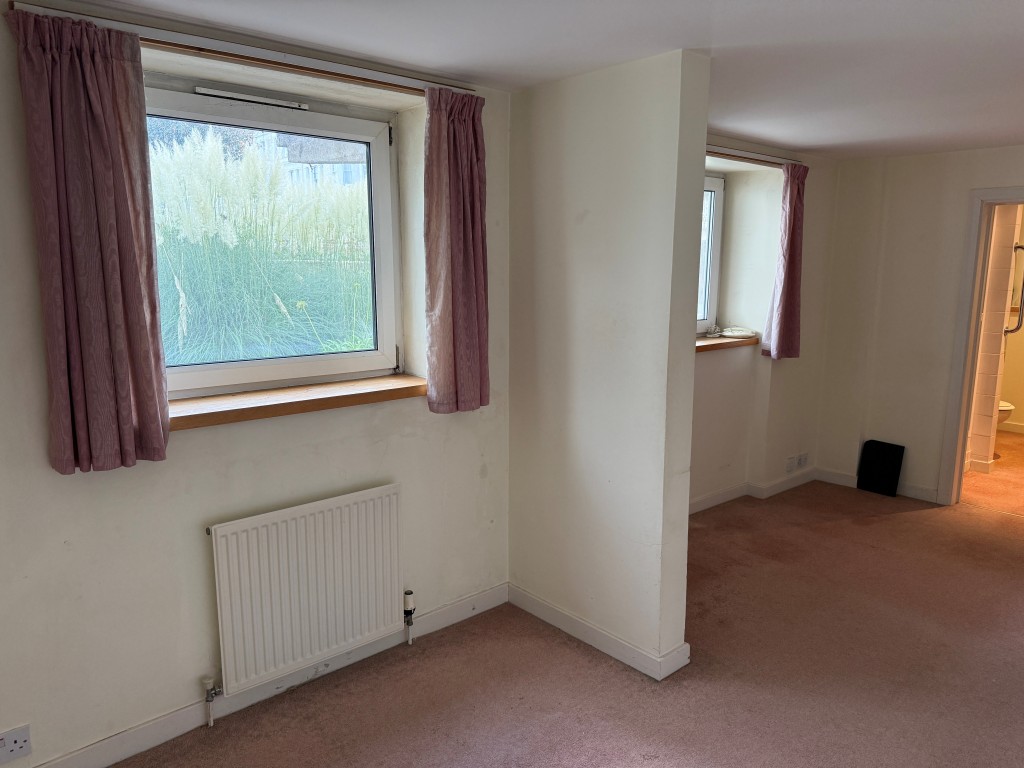 Lot: 130 - TWO-BEDROOM GROUND FLOOR FLAT IN NEED OF UPDATING CLOSE TO SEAFRONT - Main bedroom with windows overlooking gardens